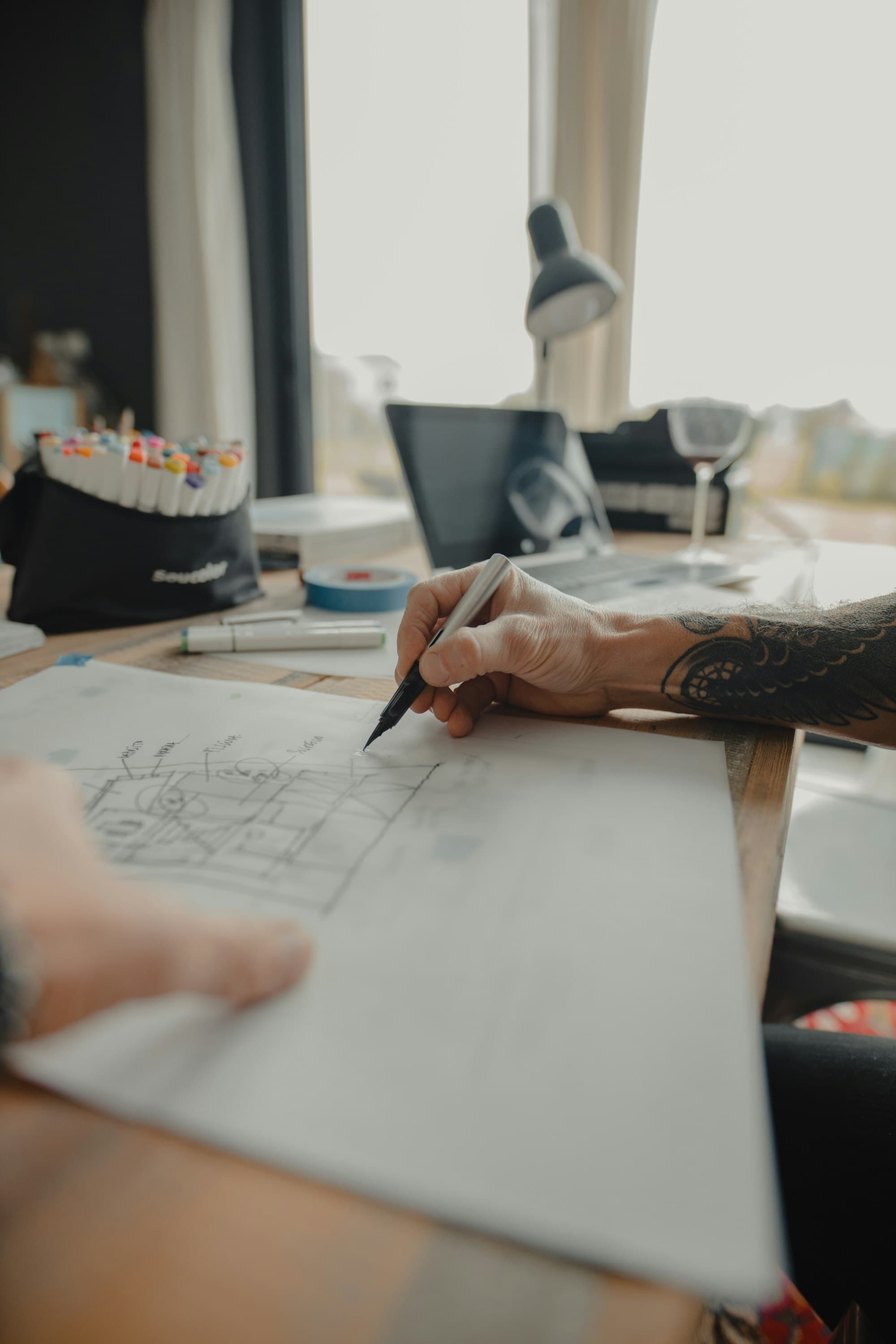 An architect sketching a design at a studio desk.